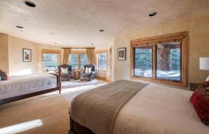 1 dormitorio con 1 cama, 2 sillas y ventanas en Cherry Ridge by AvantStay Incredible Mountain Mansion w Game Room Hot Tub Views, en Breckenridge