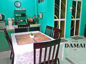 居鑾的住宿－NANIE DAMAI INN，一间设有桌子和蓝色墙壁的用餐室