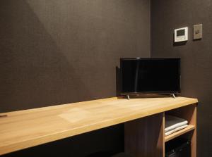 a desk with a television on top of it at 9 C Hotel Asahikawa in Asahikawa