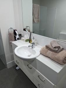 a white bathroom with a sink and a mirror at The Heart of Glenelg in Glenelg