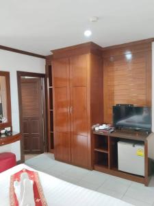 a bedroom with a bed and a desk with a television at LUCKY WAYS PATONG HOTEL in Patong Beach
