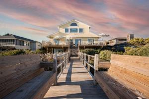 a house on a boardwalk in front of a house at Lighthouse by AvantStay Beachfront View Home w Pool Table Ping Pong in Folly Beach