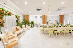 einen Bankettsaal mit Tischen, Stühlen und Blumen in der Unterkunft Heef Hotel in Jakarta