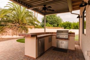 an outdoor kitchen with a stove and a patio at Desert Ridge by AvantStay Spacious Oasis w Pool Hot Tub in Phoenix