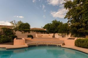 una piscina en el patio trasero de una casa con un banco en Desert Ridge by AvantStay Spacious Oasis w Pool Hot Tub en Phoenix