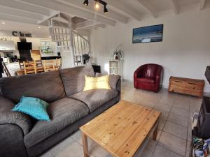 ein Wohnzimmer mit einem Sofa und einem Couchtisch in der Unterkunft Gîte Tromenec in Landunvez