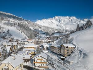 a town covered in snow with mountains in the background at Wildbach Lodge Dienten in Dienten am Hochkönig