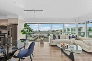 Luxurious SM Penthouse with Panoramic Ocean Views في لوس أنجلوس: غرفة معيشة مع أريكة وطاولة