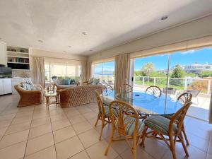 a living room with a glass table and chairs at Villa Azure - Sea Views, Pool - 70m onto Robberg 5 Beach in Plettenberg Bay