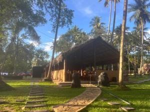 een gebouw in een park met palmbomen en gras bij Deduru Cabana Nature Resort in Kurunegala