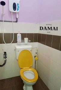 居鑾的住宿－NANIE DAMAI INN，浴室设有黄色盖子和卫生间