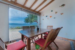 a dining room with a table and chairs and a large window at Villa Tiziana in Casa Morcone