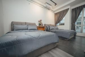 a bedroom with two beds and a couch at Modern Luxury Shoplot Style Sutera 3BR 10pax by Our Stay in Skudai