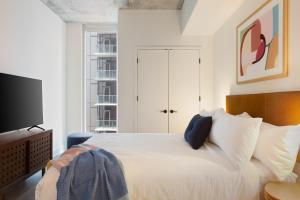 a bedroom with a white bed and a tv at Mohawk by AvantStay Brand New Condo Room in Austin w Amazing Amenities in Austin