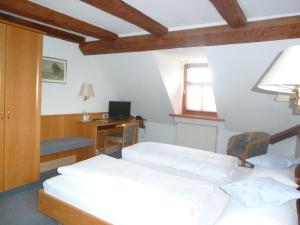 a bedroom with two beds and a desk with a computer at Brauereigasthof Adler in Oberstadion