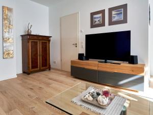 een woonkamer met een grote flatscreen-tv bij Villa "Wiederkehr" in Sellin - Wohnung 4 mit Balkon strandnah in Ostseebad Sellin