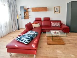 een rode leren bank in de woonkamer bij Villa "Wiederkehr" in Sellin - Wohnung 4 mit Balkon strandnah in Ostseebad Sellin