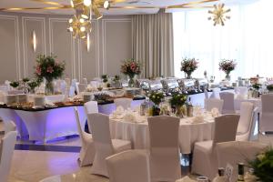 un salón de banquetes con mesas blancas y sillas blancas en Hotel Atlanta en Stare Jeżewo