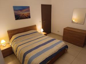 een slaapkamer met een bed met 2 nachtkastjes en 2 lampen bij Da Vinci Court in Msida