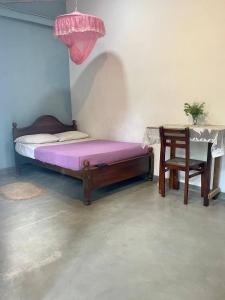 sypialnia z łóżkiem, krzesłem i stołem w obiekcie Bayview Seafood rest w mieście Weligama