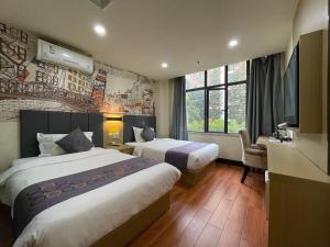 um quarto de hotel com duas camas e uma televisão em EMi Hotel Guangzhou International Convention and Exhibition Center Guangzhou Tower Branch em Guangzhou