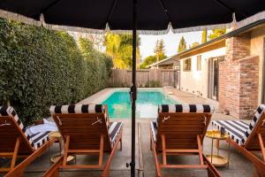 una piscina con 2 sillas y una sombrilla en Marigold by AvantStay Warm Stylish Home in Wine Country w Pool, en Santa Rosa