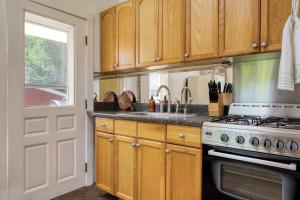 a kitchen with wooden cabinets and a stove and a window at Eloise by AvantStay Historic Upstate Apartment near Hudson River in Saugerties