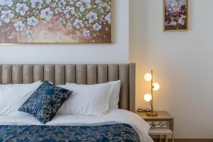 1 cama con almohadas azules y blancas y una pintura en HomesGetaway- Stylish 1BR in 1 Residence Al Kifaf Tower 1, en Dubái
