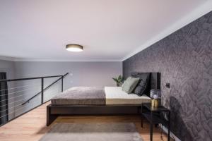 een slaapkamer met een bed en een muur bij R38 Boutique Apartments, Best Location by BQA in Boedapest