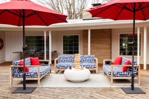 a patio with blue and white chairs and a red umbrella at Marquee By AvantStay Modern Stylish Estate w Pool Entertainers Courtyard in Boyes Hot Springs