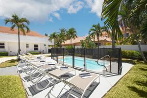 una fila de tumbonas junto a una piscina en Casa Bermuda by AvantStay Right Across the Street from Fort Lauderdale Beach, en Fort Lauderdale