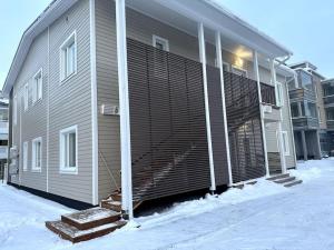 un edificio con un gran garaje con nieve alrededor en Kotimaailma Apartments#5 - Boheemi kaksio keskustassa en Seinäjoki