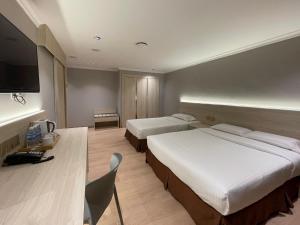 Habitación de hotel con 2 camas y escritorio en Hotel Imperial, en Kuala Lumpur