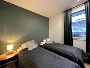 - une chambre avec deux lits à côté d'une fenêtre dans l'établissement Kotimaailma Apartments#5 - Boheemi kaksio keskustassa, à Seinäjoki