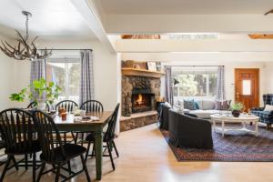 a living room with a table and a fireplace at Hartwood by AvantStay Cozy Big Bear Abode w Spacious Deck Stone Fireplace in Big Bear Lake