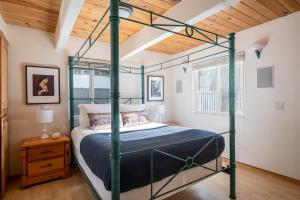 a bedroom with a four poster bed with a wooden ceiling at Hartwood by AvantStay Cozy Big Bear Abode w Spacious Deck Stone Fireplace in Big Bear Lake