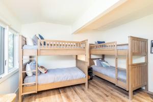 two bunk beds in a room with wooden floors at Manitou Riverhouse 115 by AvantStay Spacious Condo in the Centre of Telluride in Telluride