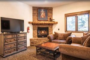 大熊湖的住宿－Big Bear Castle by AvantStay Private Home in Great Big Bear Location w Hot Tub，一间带电视和壁炉的客厅