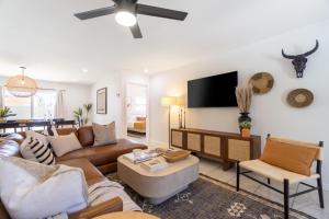 a living room with a couch and a flat screen tv at Rosario by AvantStay10mins to Old Town Scottsdale w Hot Tub in Scottsdale