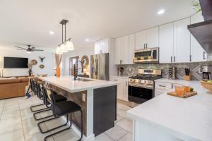 a kitchen with white cabinets and a large kitchen island at Rosario by AvantStay10mins to Old Town Scottsdale w Hot Tub in Scottsdale