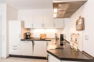 a kitchen with white cabinets and a black counter top at Döser Seedeich 7, SD2 in Cuxhaven