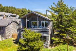 a house with a deck with chairs on it at Chapman Cove by AvantStay Gorgeous Beach Bungalow w Sauna in Cannon Beach