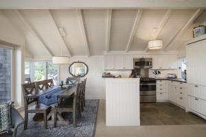 a kitchen with a table and a dining room at Chapman Cove by AvantStay Gorgeous Beach Bungalow w Sauna in Cannon Beach