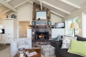 a living room with a fireplace and a couch at Chapman Cove by AvantStay Gorgeous Beach Bungalow w Sauna in Cannon Beach
