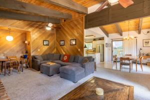 een woonkamer met een bank en een tafel bij Fawn by AvantStay Secluded Cabin w Large Deck Surrounded by Forest in Tahoma Meadows