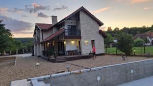 a man standing in front of a house at Pensiunea Crenguța Fermecată in Cladova