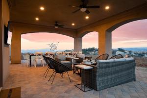 a patio with a table and chairs and a ceiling fan at Malbec by AvantStay Incredible Estate w Panoramic Views Bocce Ball Court in Sage
