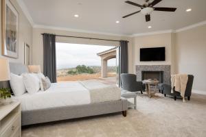 a bedroom with a large bed and a fireplace at Malbec by AvantStay Incredible Estate w Panoramic Views Bocce Ball Court in Sage