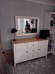 Vestidor blanco con espejo y árbol de Navidad en Beautiful cottage near London, en Maidenhead