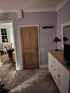 Habitación con puerta y mesa con lámpara en Beautiful cottage near London, en Maidenhead